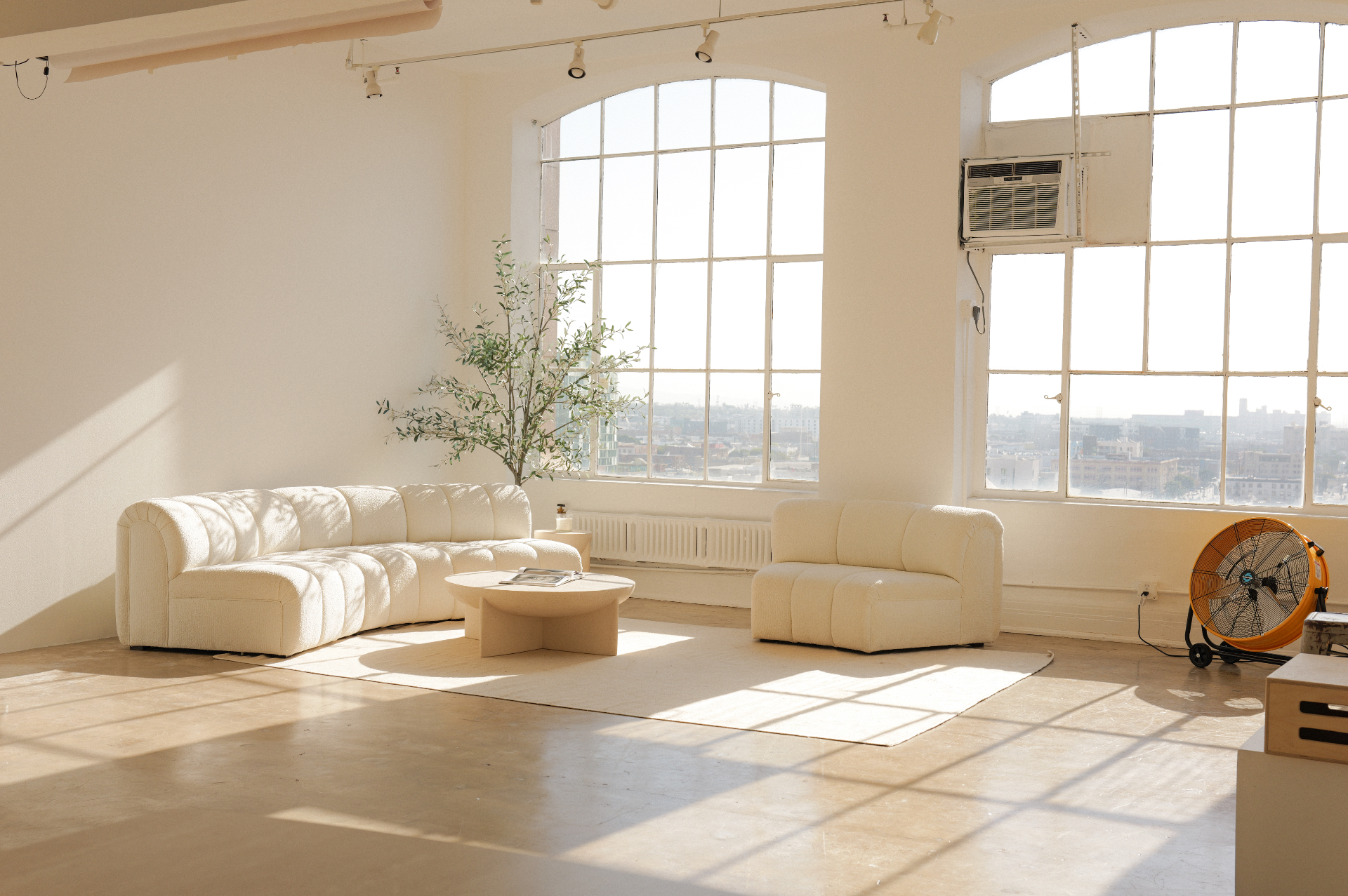 Studio 1112, the original Leitner studio: arched windows, daylight and a white bouclé sofa in Downtown Los Angeles